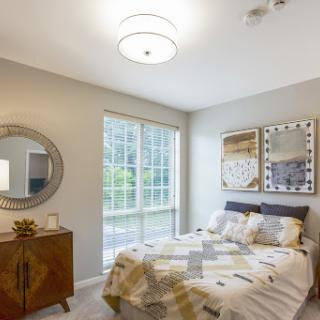 A modern and well-lit bedroom featuring stylish decor and comfortable furnishings.