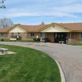 A suburban residential building with a well-maintained lawn and driveway.