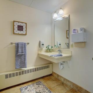 A well-lit bathroom featuring a sink, mirror, and decorative elements.
