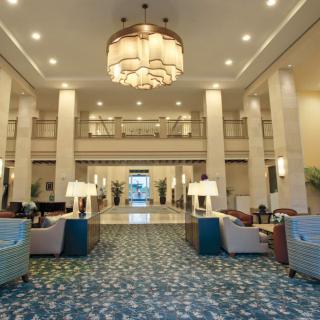 A luxurious hotel lobby with elegant seating and a large chandelier.