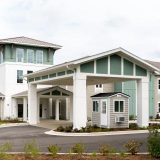 A modern residential building with a welcoming entrance and landscaped surroundings.