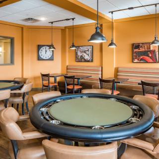 A well-arranged poker room with a central table and comfortable seating.