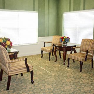 A cozy and elegantly decorated seating area with striped chairs and a table adorned with fresh flowers.