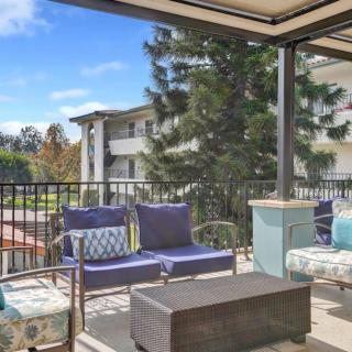 A cozy outdoor balcony with comfortable seating and a scenic view of the surrounding area.