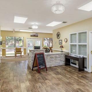 A modern reception area with wood flooring and comfortable seating.