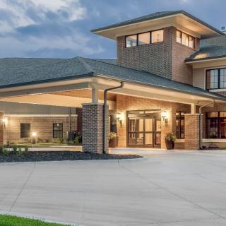 A modern house with a spacious driveway in the evening light.