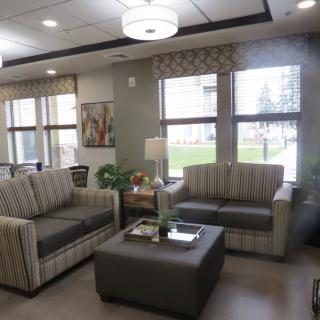 A cozy living room with matching sofas, a central coffee table, and large windows.
