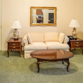 A traditional living room setup featuring a sofa, coffee table, and matching lamps on side tables.