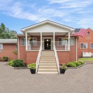 A charming brick house with a welcoming entrance and American flag.
