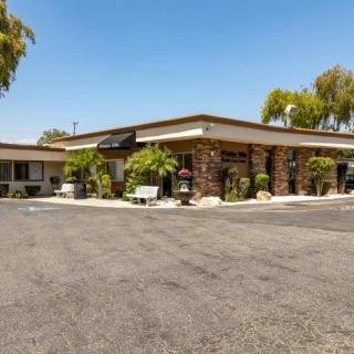 A view of a motel with a parking lot and surrounding trees.