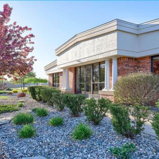 A commercial building with well-maintained landscaping and a clear blue sky.