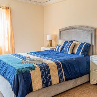 A cozy and well-decorated bedroom with a stylish blue bedding set.
