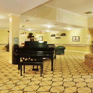 A spacious hotel lobby featuring a grand piano and stylish furnishings.