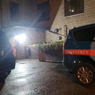 Emergency response vehicles parked outside a building at night.