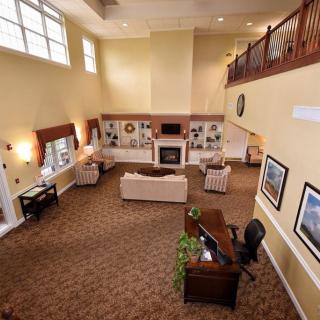 Spacious living room with high ceilings, comfortable seating, and a cozy fireplace.