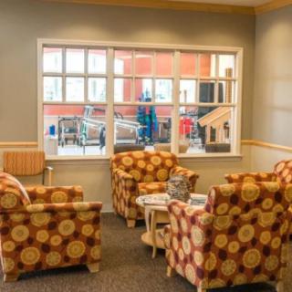 A cozy lounge area with patterned chairs and a large window.