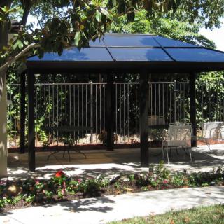 A gazebo surrounded by greenery in a landscaped garden.