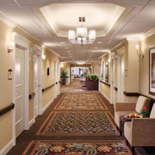 A well-lit hallway with elegant carpeting and seating areas.