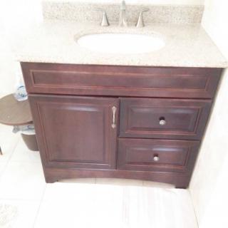 A dark wooden bathroom vanity with a sink and storage drawers.