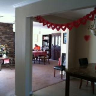 A cozy living room decorated with red heart garlands for a celebration.