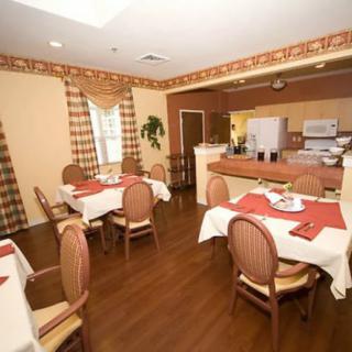 A cozy dining area with neatly arranged tables and chairs, featuring warm neutral tones.