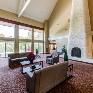 A spacious and modern lobby area with large windows and a prominent fireplace.