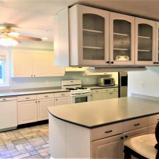 A modern kitchen interior with white cabinets and a spacious countertop.