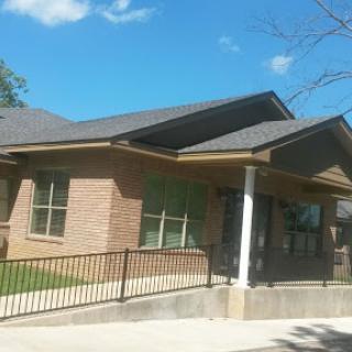 A charming residential building featuring a modern design and spacious porch.