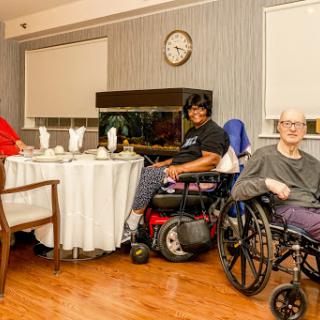 Residents enjoying time together in a care facility's dining area.