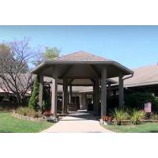 A welcoming entrance to a building surrounded by landscaped greenery.