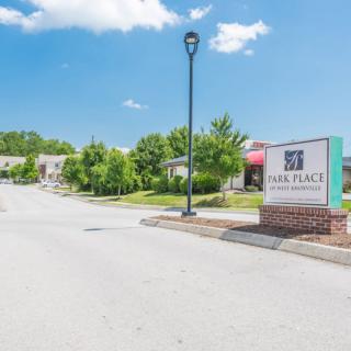 A view of a building entrance with a sign and a clear sky.