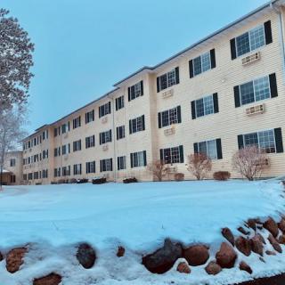 A residential apartment building surrounded by snow on a winter day.