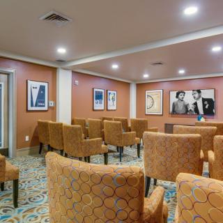 A small meeting room with upholstered chairs and artwork on the walls.