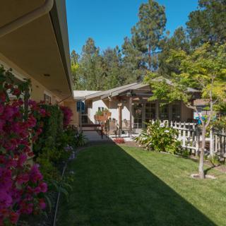 A serene backyard with a garden, patio, and vibrant flowers.