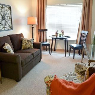 Cozy living room with a sofa, chairs, table, and warm lighting.
