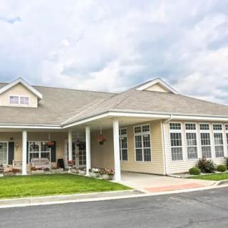 A spacious suburban house with a well-maintained lawn and a covered entrance.
