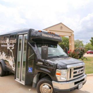 A black shuttle bus parked outside a building, labeled 'Texas Health Presbyterian Hospital.'