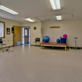 An empty exercise room with yoga balls and gym equipment.