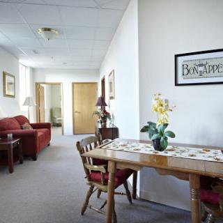 A cozy living and dining space featuring a wooden table, chairs, and decorative elements.