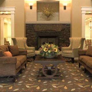 A cozy living room with sofas, armchairs, and a fireplace.