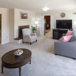 A cozy living room with modern furniture and a large television.