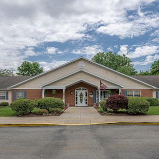 A welcoming entrance to a residential building against a cloudy sky.
