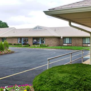 A single-story brick building with a neatly landscaped driveway.