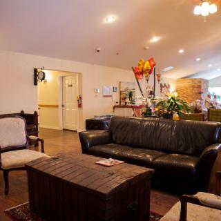 A cozy living room with a sofa, chairs, and a coffee table, warmly lit for comfort.