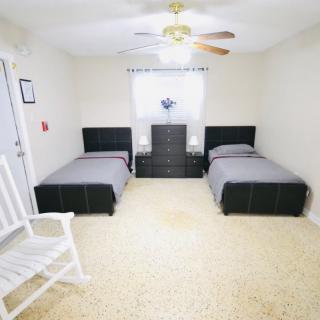 A bedroom with twin beds, a dresser between them, and a rocking chair in the corner.