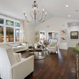 A modern living room with elegant decor and a large chandelier.