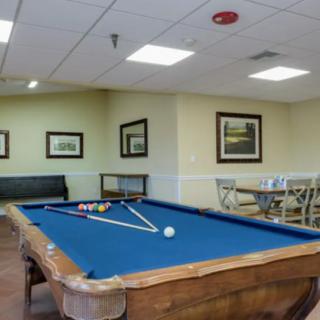 A cozy game room featuring a pool table and comfortable seating.