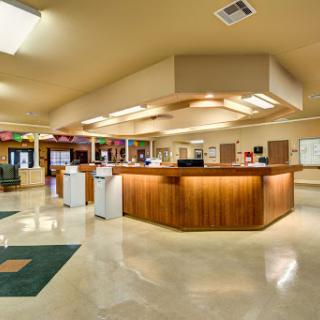 A spacious and modern reception area with a wooden counter and comfortable waiting space.