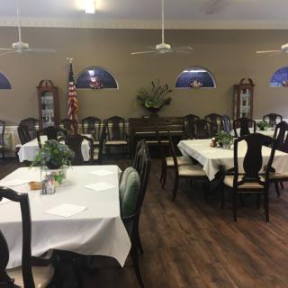 A cozy dining room with neatly set tables and elegant chairs.