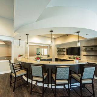 A modern kitchen with a circular bar counter and stylish seating.